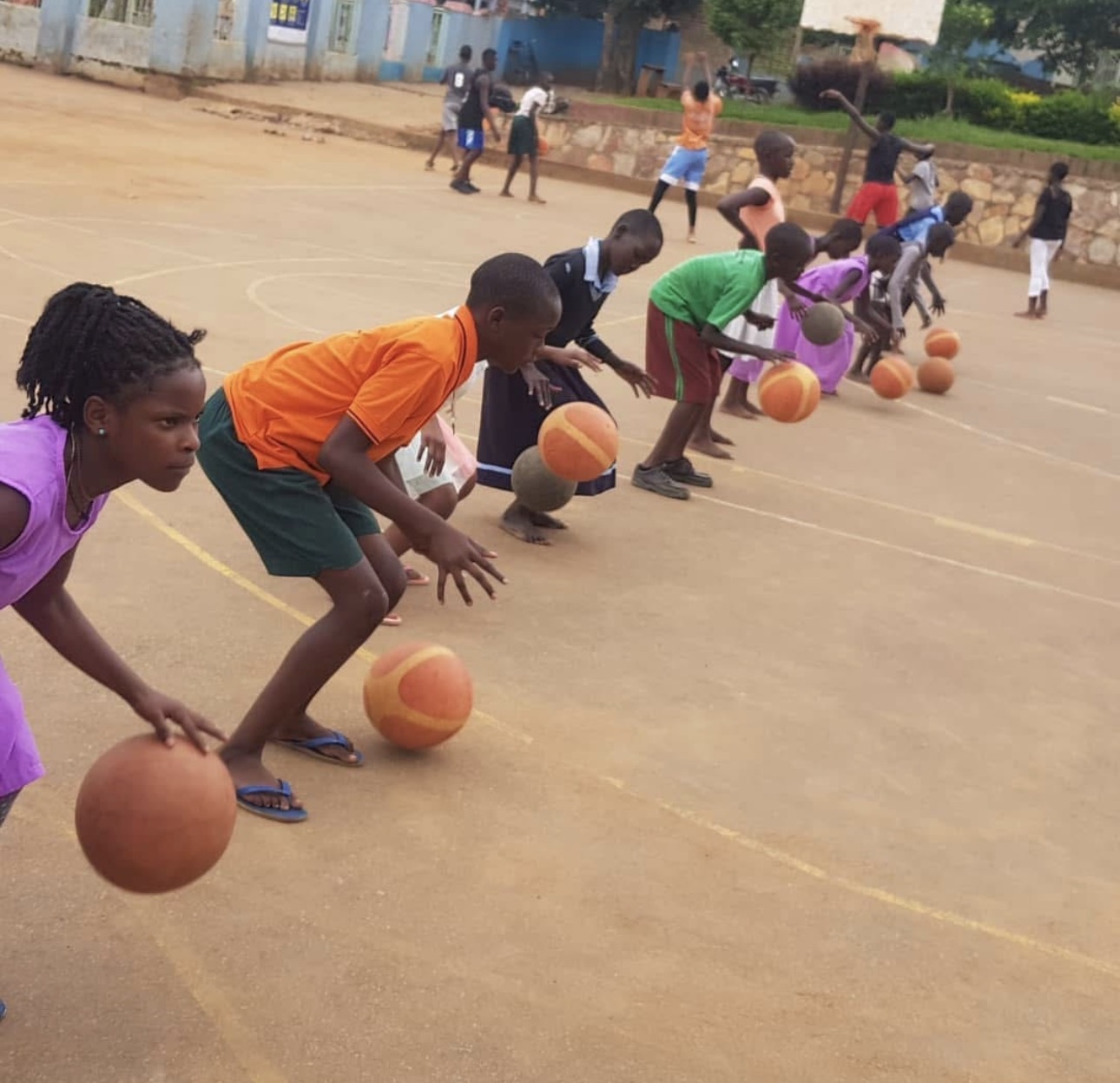 Line of children practicing dribbling drills