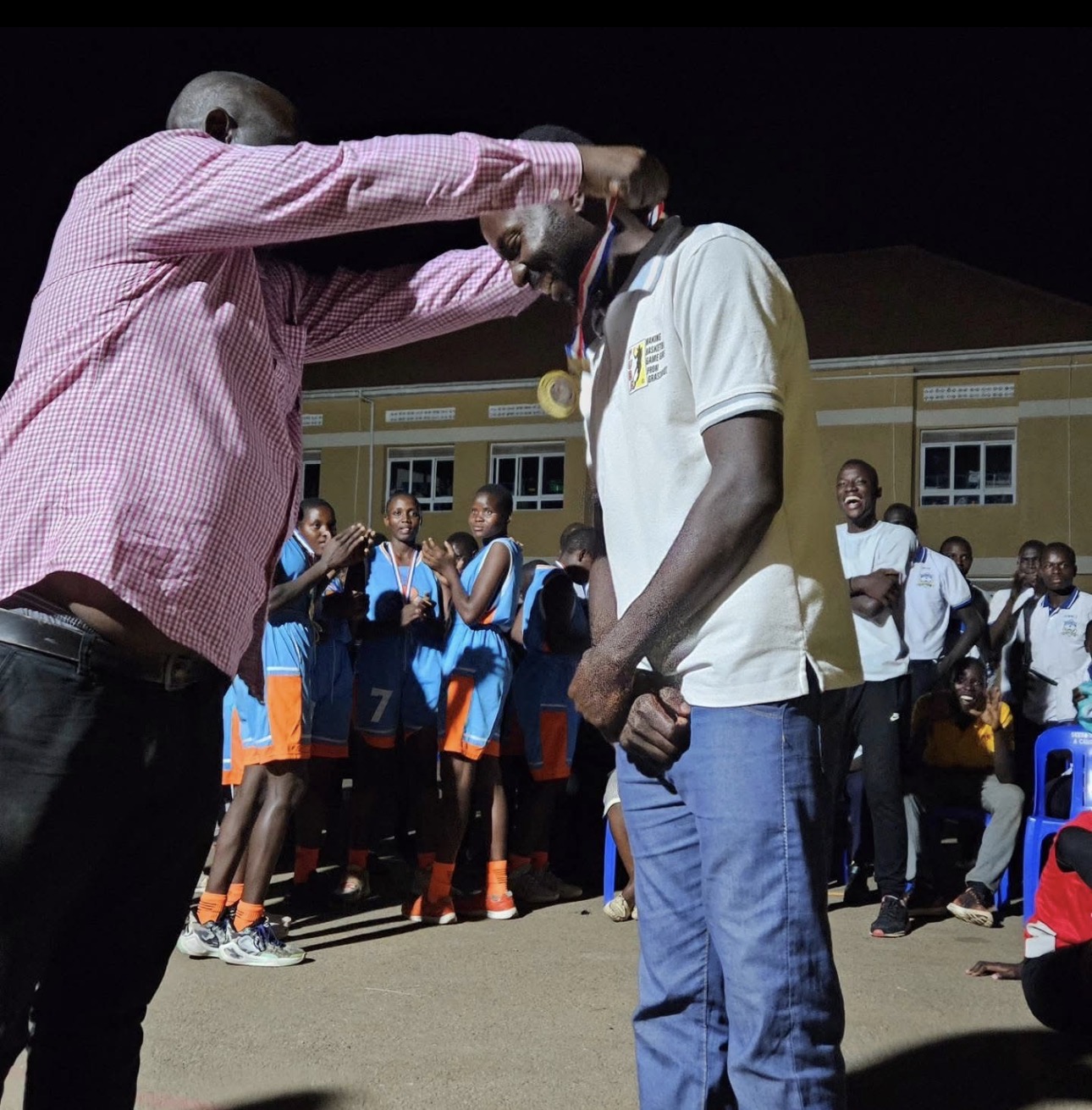 Coach receiving a medal from the school's leadership